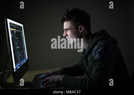 Young man hacking server in dark room Stock Photo