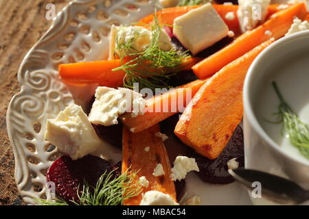 Healthy grilled beet, carrots salad with cheese feta, fennel and Greek yogurt in small glass bowls on the rustic wooden table, top view Stock Photo