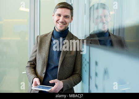 Smiling Businessman Holding Tablet Stock Photo
