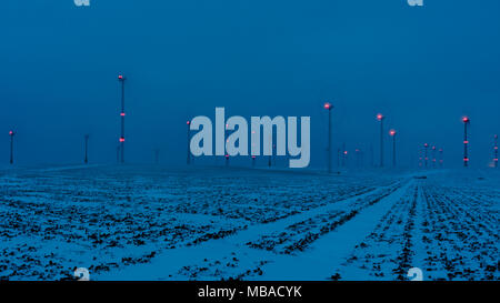 wind farm in the night with signal lights and a blue sky Stock Photo
