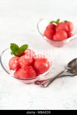 Watermelon cut in small balls and served in glass dishes on wooden table Stock Photo