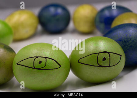 Close up of red, blue, green and purple easter eggs on a white plate Stock Photo