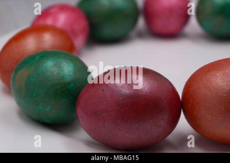 bright colorful Easter eggs on red plate on pink background Stock Photo