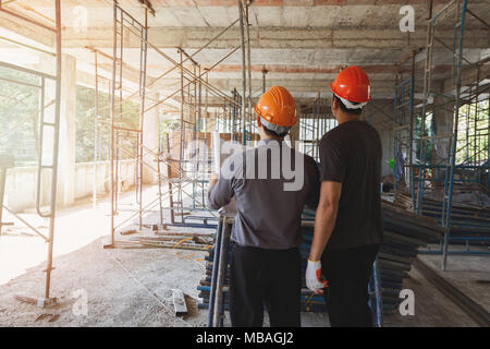 Engineer discussing with foreman about project in building construction site Stock Photo