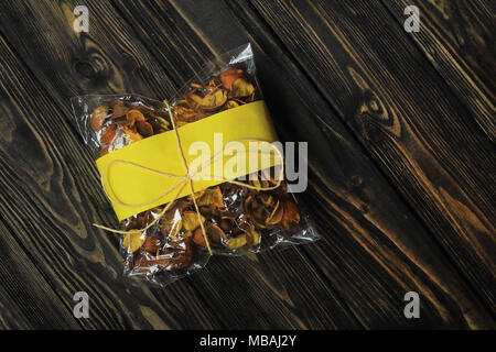 cellophane bag with dried fruits on dark wooden background Stock Photo