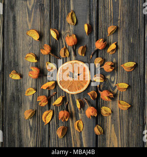 orange and dry hibiscus flowers on wooden background Stock Photo