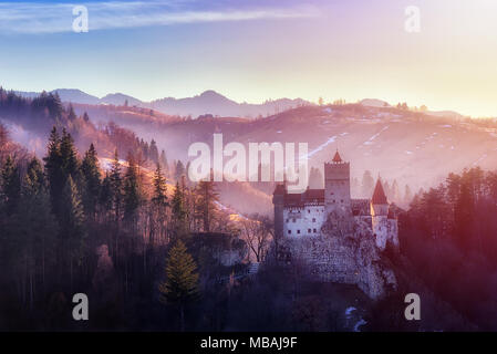 Bran or Dracula Castle in Transylvania, Romania. The castle is located on top of a mountain, sunset light