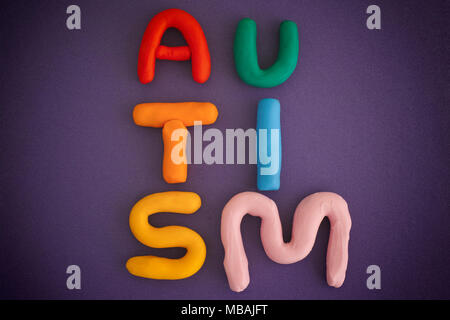 Autism. Autism spectrum disorder. Autism word made out of playdough. Purple background. Close up. Stock Photo