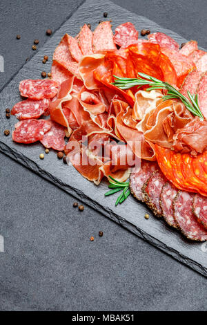 Various types of Dried organic salami sausage and parma on concrete ...