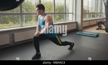 Young muscular man warming up in the gym Stock Photo