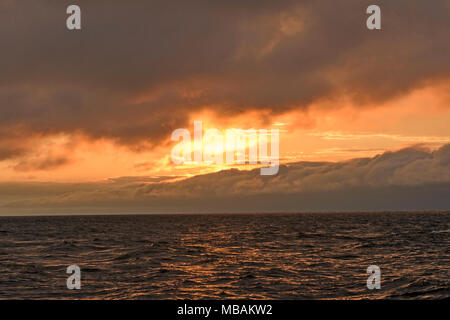 Sun Peeking Through the Clouds over Waves on Lake Superior in Porcupine Mountains State Park in Michigan Stock Photo