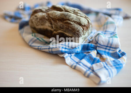 Brown bread on a table with a plaid towel Stock Photo