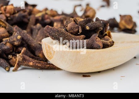 Spice carnations on a white kitchen table. Fragrant spices for gingerbread and mulled wine. Light background. Stock Photo