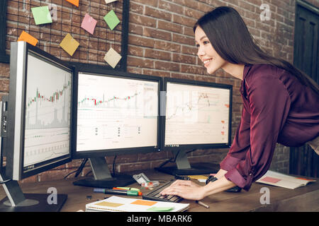 Woman analyzing data, graphs and reports for investment purposes. Indoor, studio shot. Business people concept, work in office Stock Photo