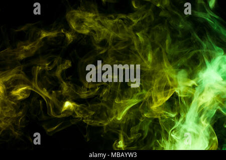 Dense multicolored smoke of    green colors on a black isolated background. Background of smoke vape Stock Photo