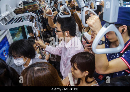 Tokyo Japan,Ikebukuro,JR Ikebukuro Station,Yamanote Line,Asian man men male adult adults,woman female women,crowded,standing,commuters,train car,strap Stock Photo