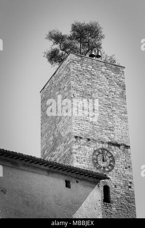 Isolated clock tower with a garden and bells on the roof (Spello, Umbria, Italy) Stock Photo