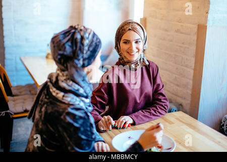 Two Muslim women in cafe, friends meeting Stock Photo