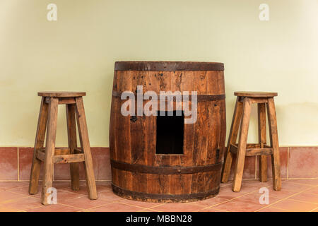 barrel with perforation used as table. Two stools. Everything in the gallery of a house Stock Photo
