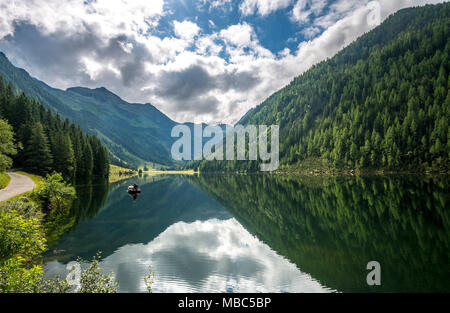 Angler in a boat, reflection in the lake, Riesachsee, Rohrmoos-Untertal, Schladminger Tauern, Schladming, Styria, Austria Stock Photo
