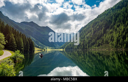 Angler in a boat, reflection in the lake, Riesachsee, Rohrmoos-Untertal, Schladminger Tauern, Schladming, Styria, Austria Stock Photo