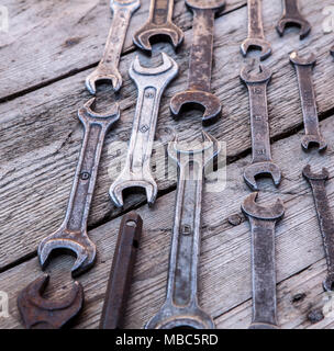 Metal wrench rusty tools lying on a black wooden table. Hammer, chisel, hacksaw, metal wrench. Stock Photo