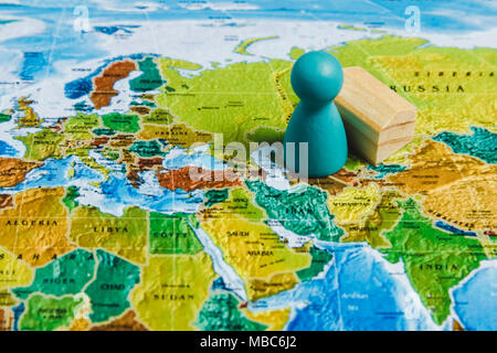 Travelling Concepts. Traveler Miniature Mini Figures Standing on World Map. Stock Photo