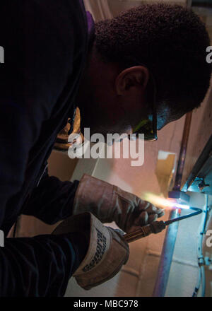 OCEAN (Feb. 15, 2018) Hull Technician 3rd Class Moses Davis, from Miami, repairs a pipe in a gear locker aboard the dock landing ship USS Oak Hill (LSD 51). The Iwo Jima Amphibious Ready Group embarks the 26th Marine Expeditionary Unit and includes Oak Hill, the amphibious assault ship USS Iwo Jima (LHD 7), the amphibious transport dock ship USS New York (LPD 21), Fleet Surgical Team 8, Helicopter Sea Combat Squadron 28, Tactical Air Control Squadron 22, components of Naval Beach Group 2 and the embarked staff of Amphibious Squadron 4. (U.S. Navy Stock Photo