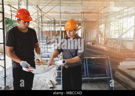 Engineer discussing with foreman about project in building construction site Stock Photo