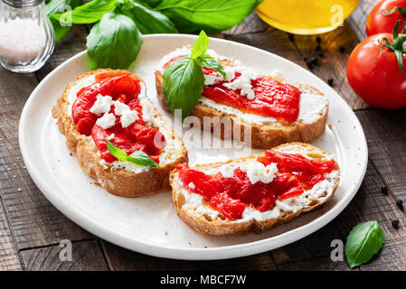 Italian antipasti bruschetta with roasted pepper, olive oil and goat cheese or feta cheese. Rustic style. Selective focus Stock Photo
