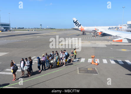 Passengers queueing on the apron to board a Jetstar Airbus A320 aircraft from the rear at Sydney airport, domestic terminal, Australia Stock Photo