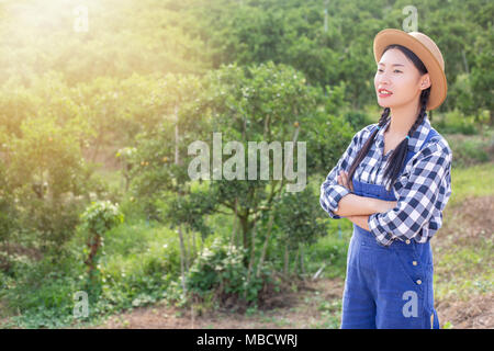 happy asia farmer posing in a orange Garden Stock Photo