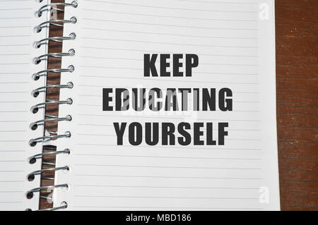 keep educating yourself written on white paper Stock Photo
