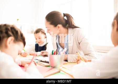 Small students with teacher painting in art school class Stock Photo