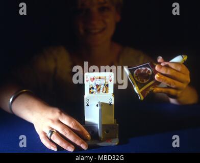 Stage Magic - Card Tricks Deck of cards placed ina special wooden holder. When the magician rings a bell a predetermined card rises from the pack. Stock Photo