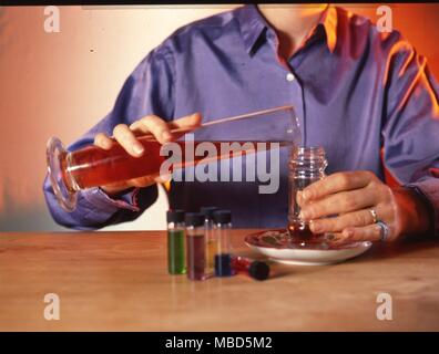 Occult Philosophy, Herbal Medicine, Massage Oils and equipment. Person pouring massage oil into a container. Stock Photo