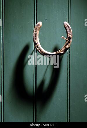 Horseshoe nailed to a door for good luck Stock Photo