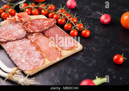 Different antipasto appetizers on wooden board Stock Photo