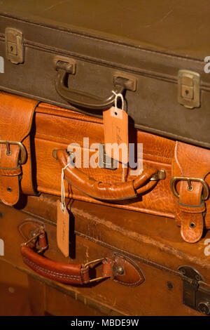 stack of brown leather suitcases used in the set design of a theatrical show Stock Photo