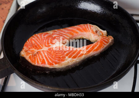 Fresh salmon steaks being marinated in pot and fried Stock Photo