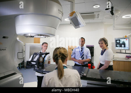 Prime Minister Theresa May (right) is shown the advanced radiotherapy system during her visit to Addenbrooke's Hospital in Cambridge, where she announced new research and funding for prostate cancer treatment, and met NHS staff to discuss the challenges they face as the Government prepares to bring forward a long-term plan for the health service. Stock Photo