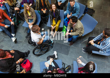 Overhead view speaker in wheelchair with microphone talking with audience Stock Photo