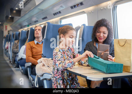 Mother and daughter with shopping bags on passenger train Stock Photo