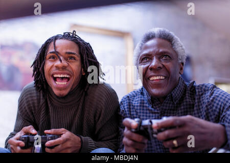 Enthusiastic grandfather and grandson playing video game Stock Photo