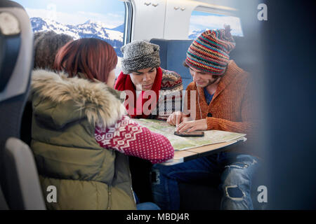 Young friends with map planning on passenger train Stock Photo