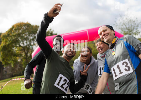 Friend runners taking selfie at charity run in park Stock Photo