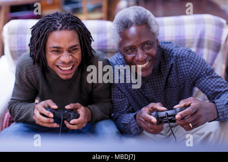 Happy grandfather and grandson playing video game Stock Photo