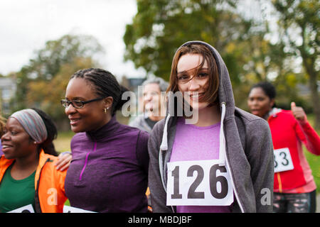 Portrait smiling female runner at charity run in park Stock Photo