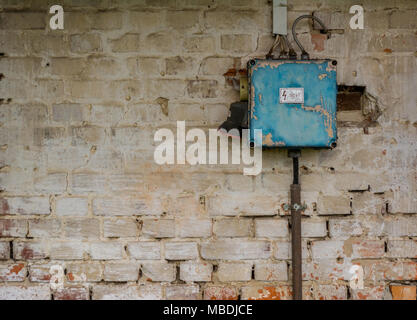 Old bad rusty switch box on weathered wall Stock Photo