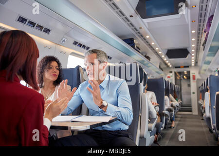 Business people working, talking on passenger train Stock Photo